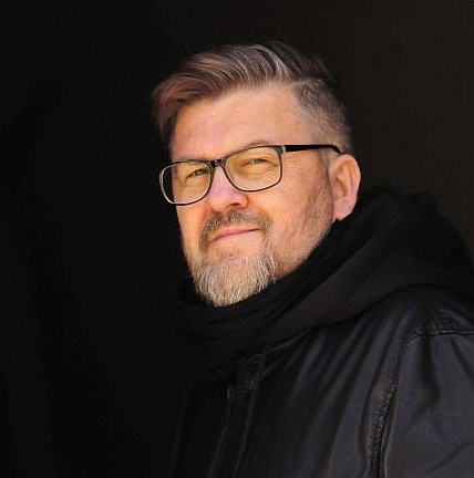 Grzegorz Linkowski w okularach i ciemniej kurtce